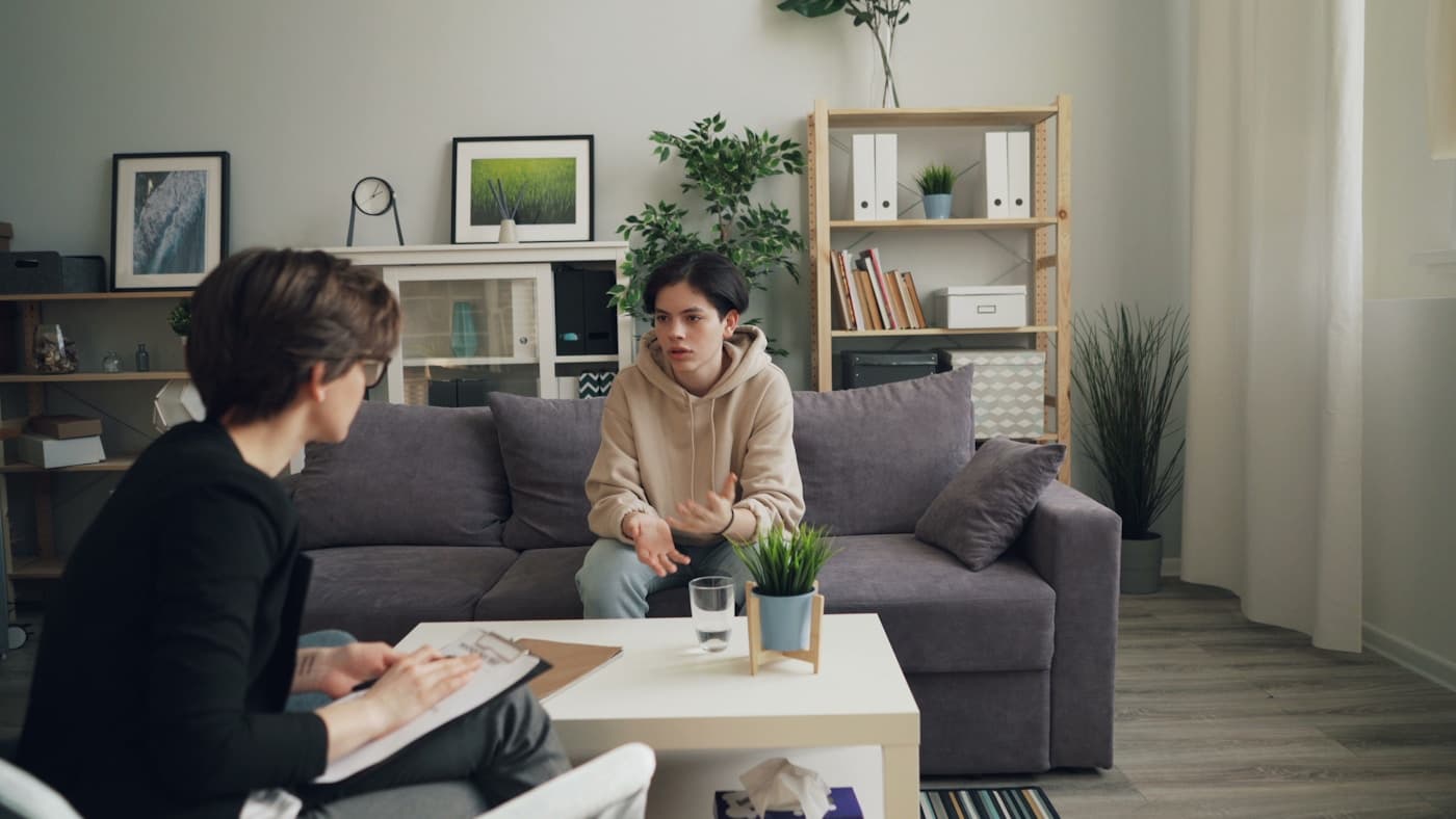 A student speaking with a therapist in a calm room